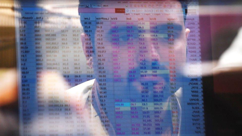 A Pakistani stockbroker is reflected in a monitor as he watches share prices during a trading session at the Pakistan Stock Exchange (PSX) in Karachi on May 24, 2017