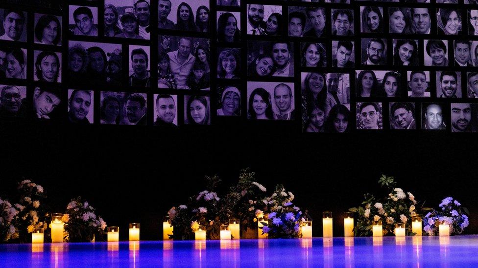 Candles are lit in front of the photos of the victims of the downing of Ukraine International Airlines flight PS752, in Toronto, Canada (8 January 2023)