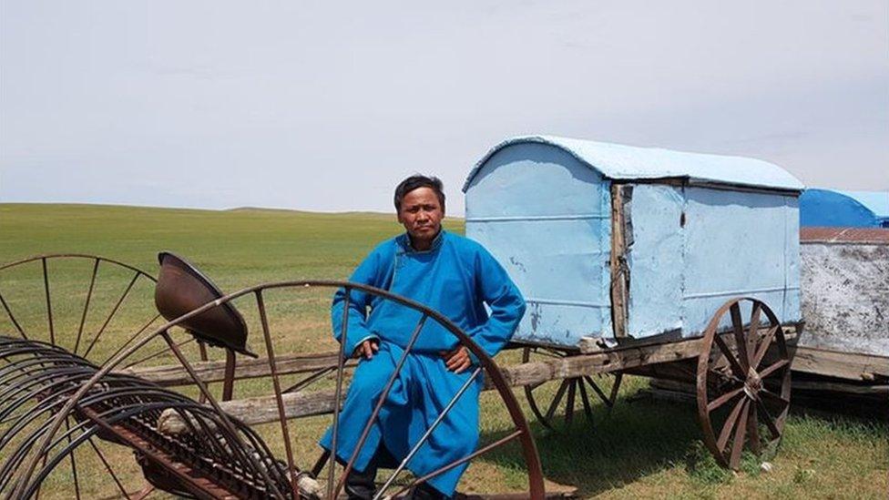 Batmunkh sitting on farming equipment