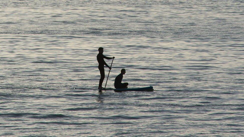 Two paddleboarders taking in the sights near South Beach in Aberystwyth