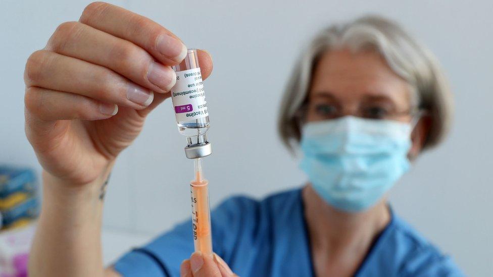 A woman holding a vaccine