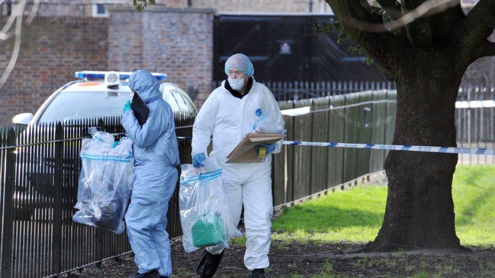 Forensic officers remove items of evidence including a green petrol can after searching an area where a man was found on fire near Kensington Palace in the early hours of Tuesday morning