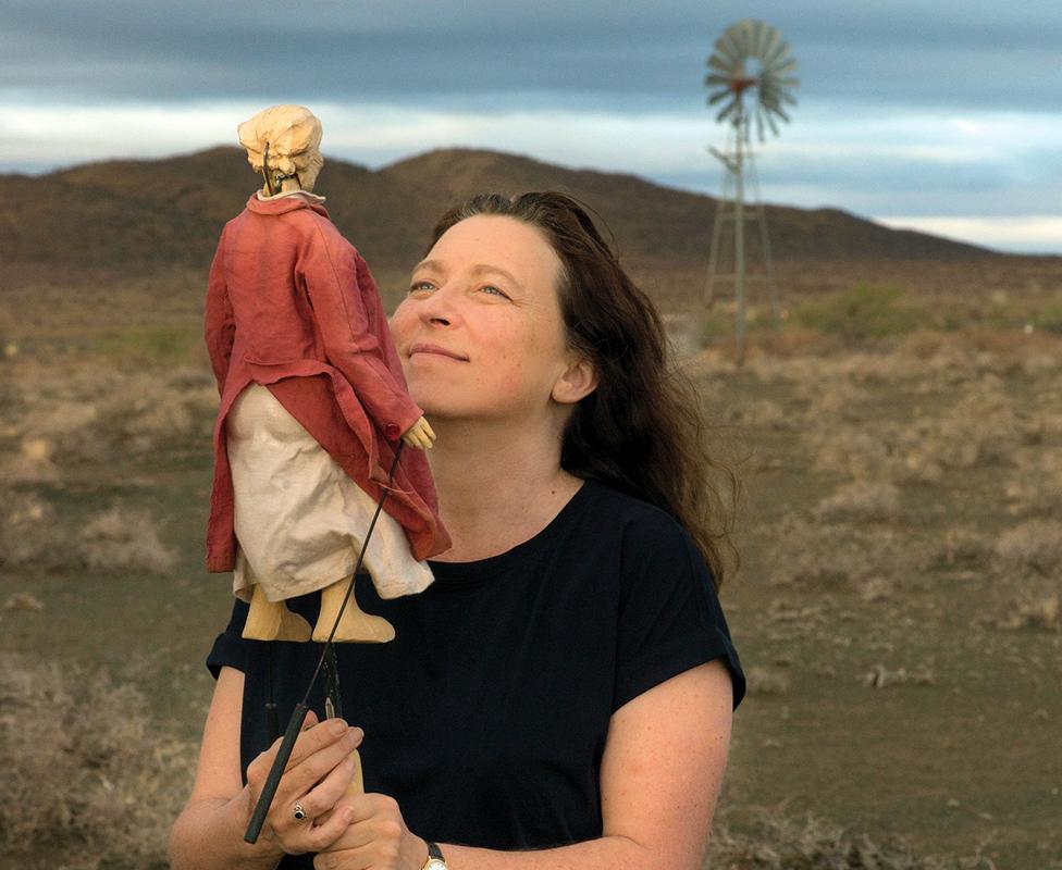 Lara Foot with a puppet and a windmill in the background