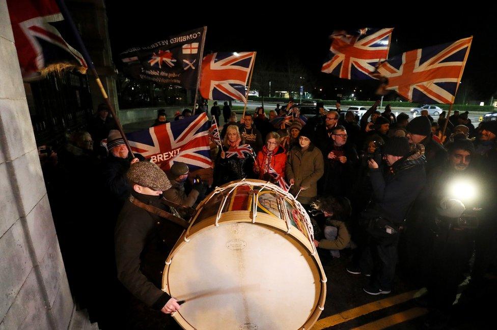 People gathered outside the Stormont estate in Belfast, waving union flags to mark the moment of Brexit