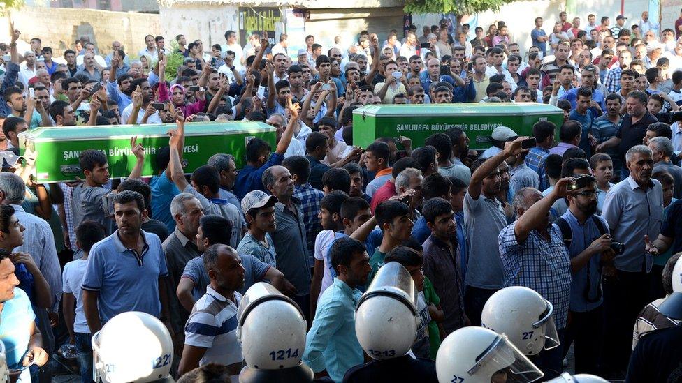 People shout slogans while they carry the coffins of victims of a suicide bombing in the Turkish town of Suruc on 20 July 2015