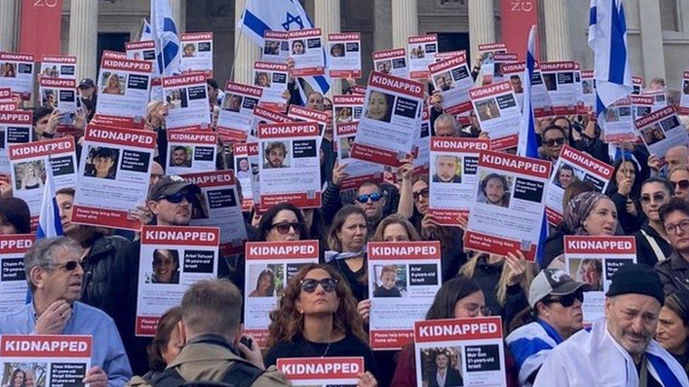 Members of the Jewish community show posters of missing Israelis