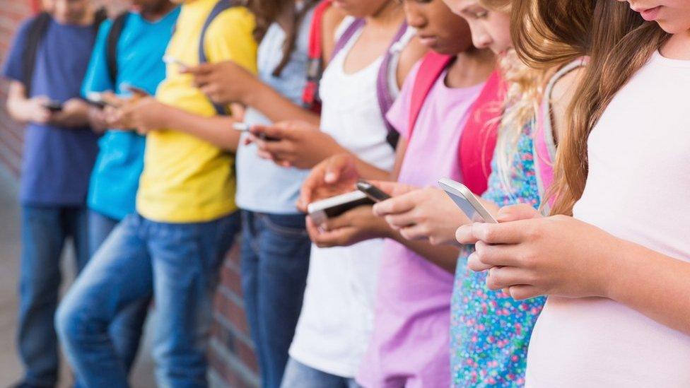 children holding phones