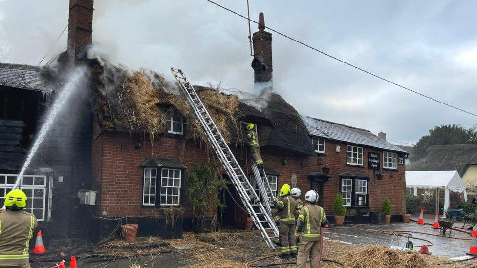 Firefighters tackling a blaze at the Axe and Compasses pub