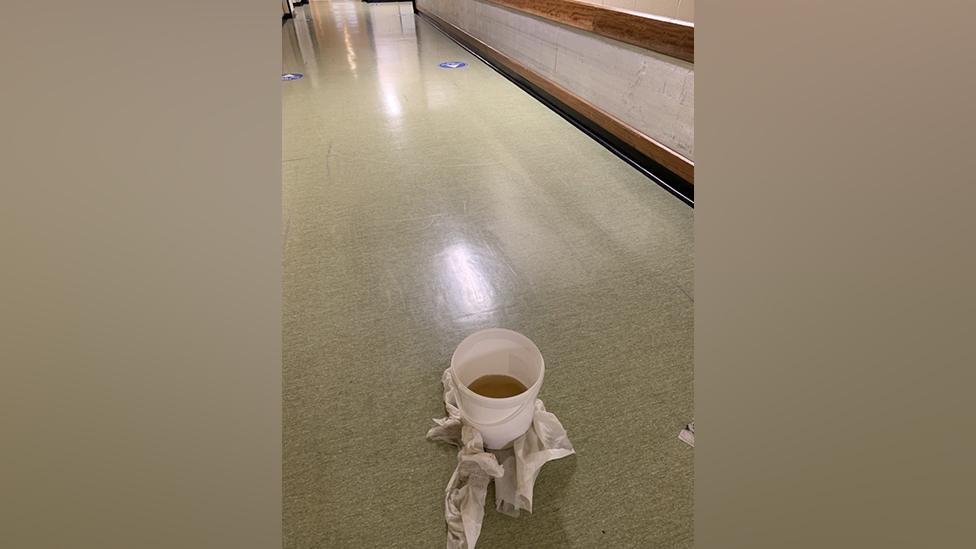 A bucket catches rainfall in hospital corridor at the Queen Elizabeth Hospital, King's Lynn