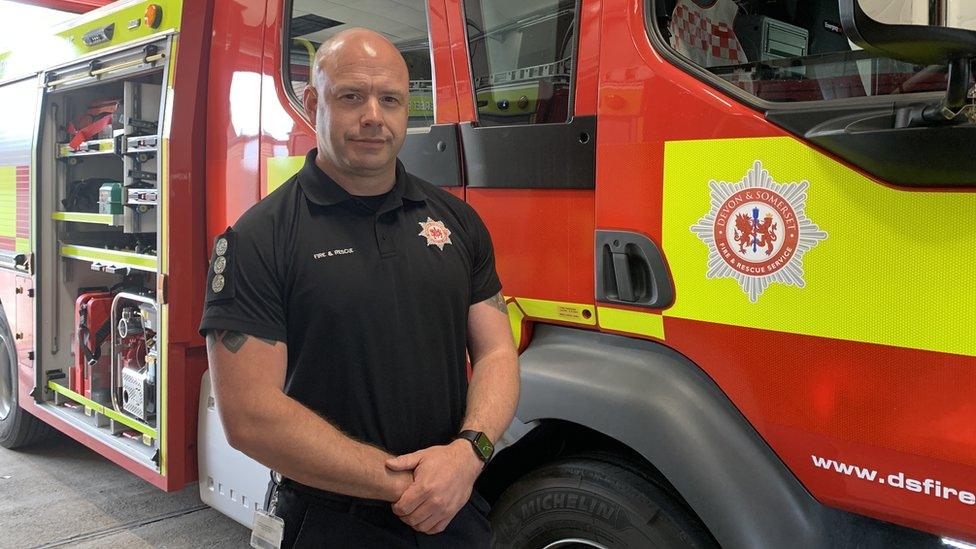 Dominic Mallett standing in front of a fire engine