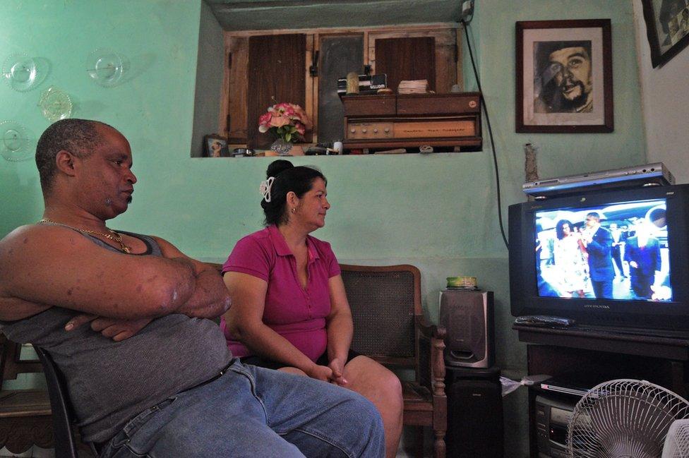 A family in Havana, watch TV coverage of the arrival of US President Barack Obama to Cuba