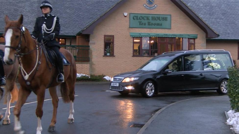 Hearse with mounted officer