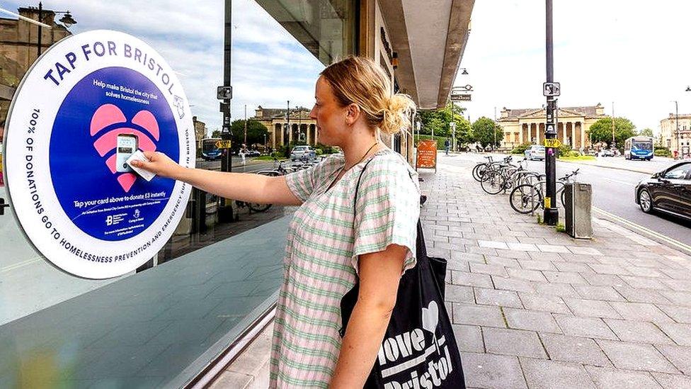 A women tapping a donate area