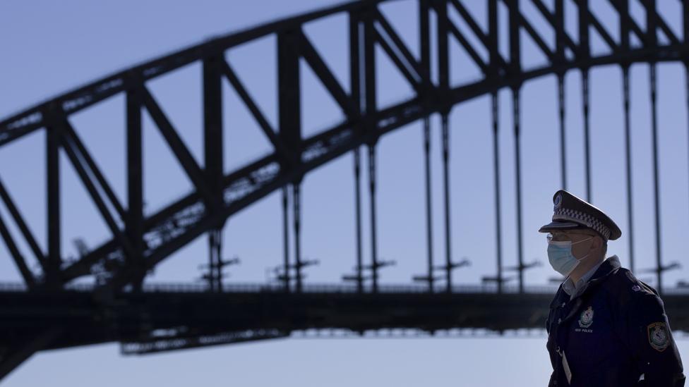 A police officer is seen near Harbour Bridge in Sydney, Australia, July 18, 2021. Rising COVID-19 cases sparked tougher restrictions with more retail closed in Australia's state of New South Wales (NSW).