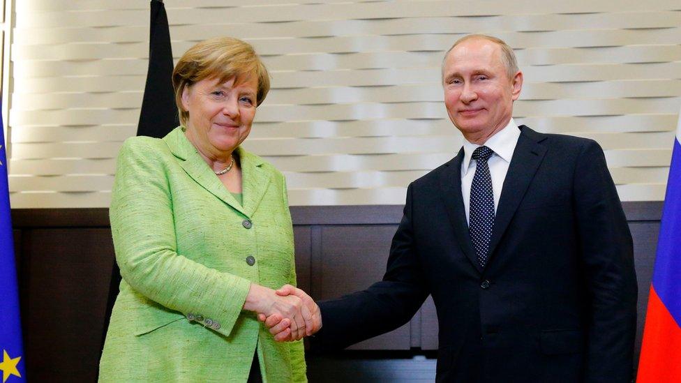 Merkel shakes hands with Putin