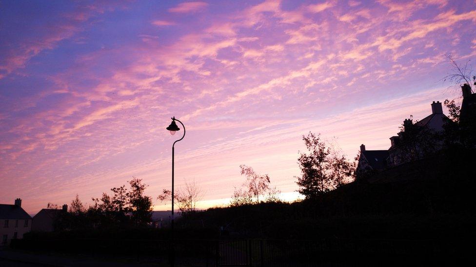 Silhouette of a residential street at dawn with Stratocumulus cloud formation.