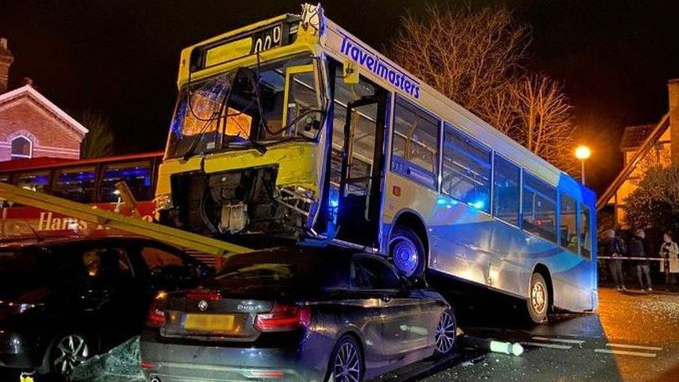 A photo of a bus on top of a parked car