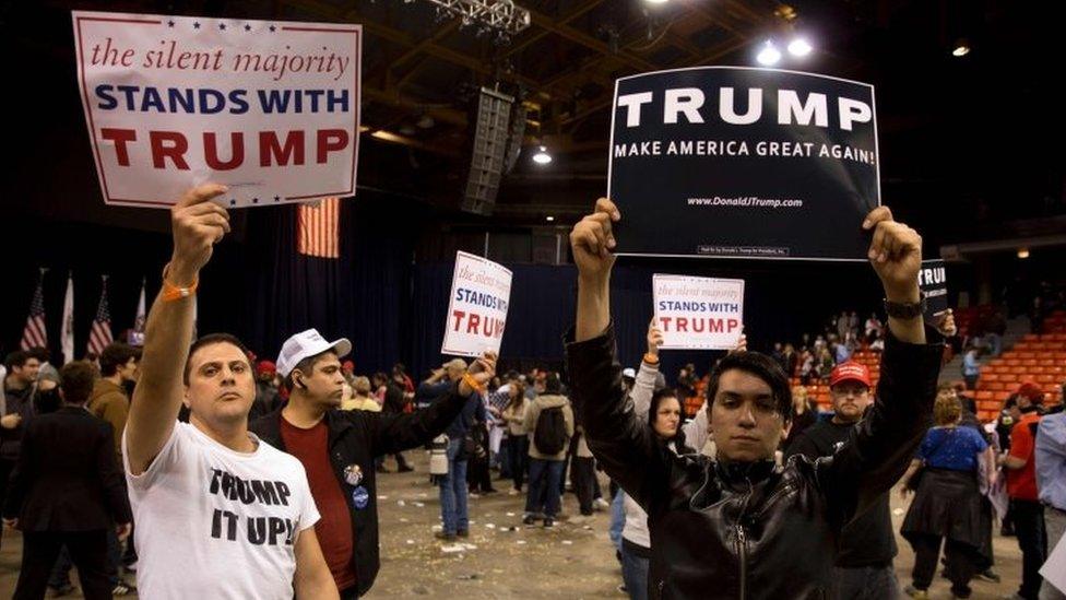 Trump supporters hold campaign signs during a Trump rally at the UIC Pavilion in Chicago