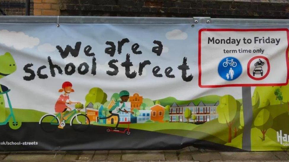 Banner showing "we are a school street" and pictures of children on bikes