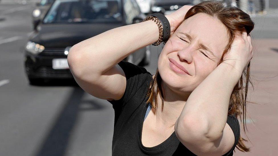 Woman holding her ears