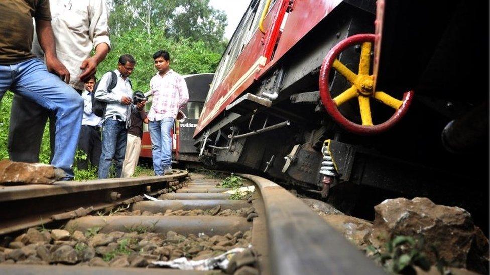 People gather at the site of the derailment of a chartered narrow gauge train