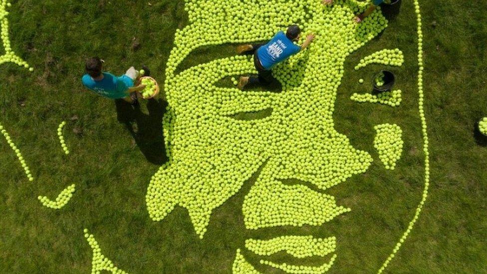 Giant tennis ball mosaic near No.1 Court showing Tefy from Madagascar enjoying clean water.