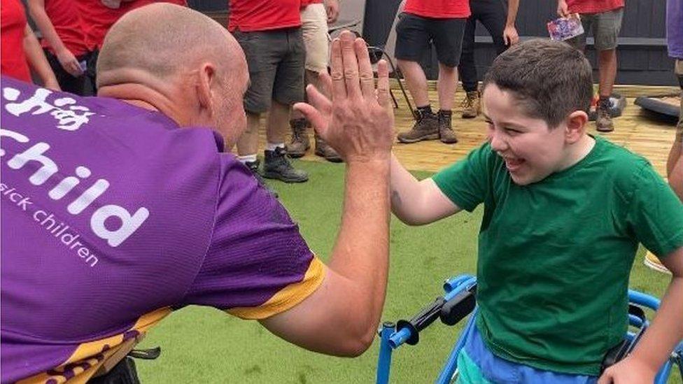 A young boy giving a high five to a man