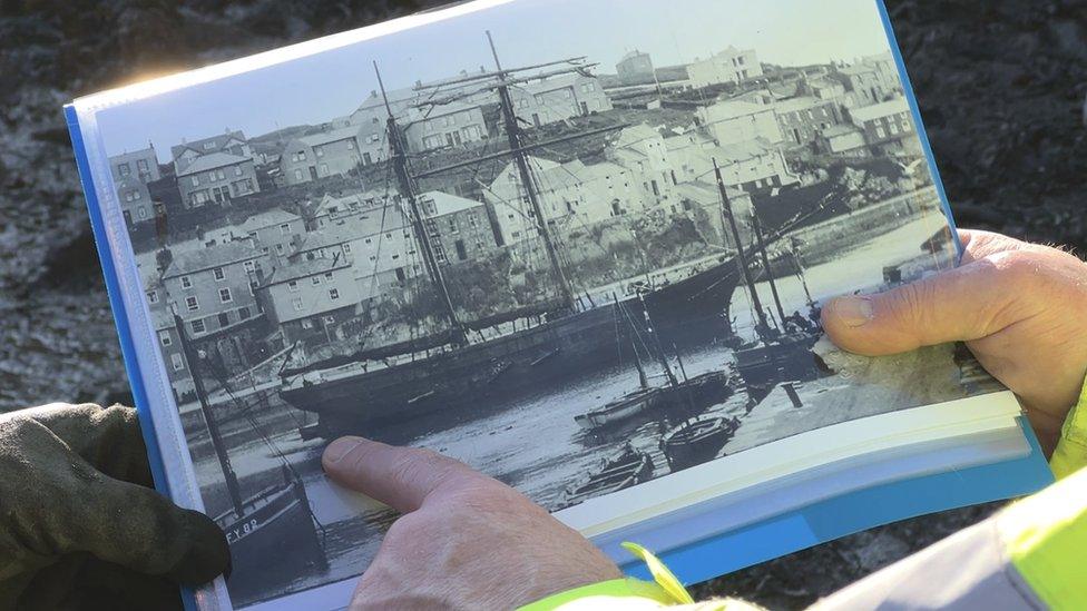 Mallory Haas and Peter Holt looking at an old photo of the John Sims