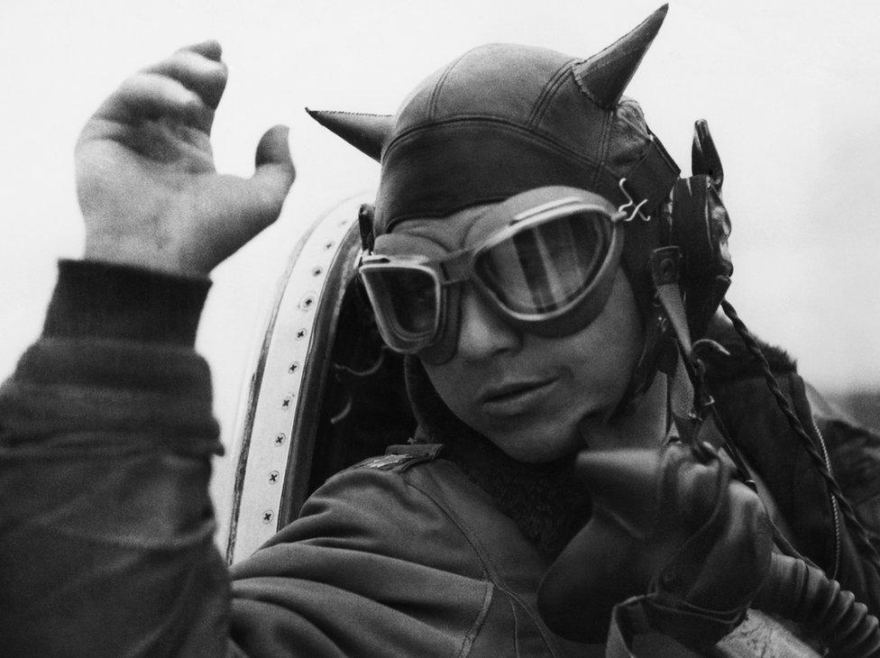 Lieutenant Colonel Louis Houck dons his 'devil's helmet' prior to a mission.