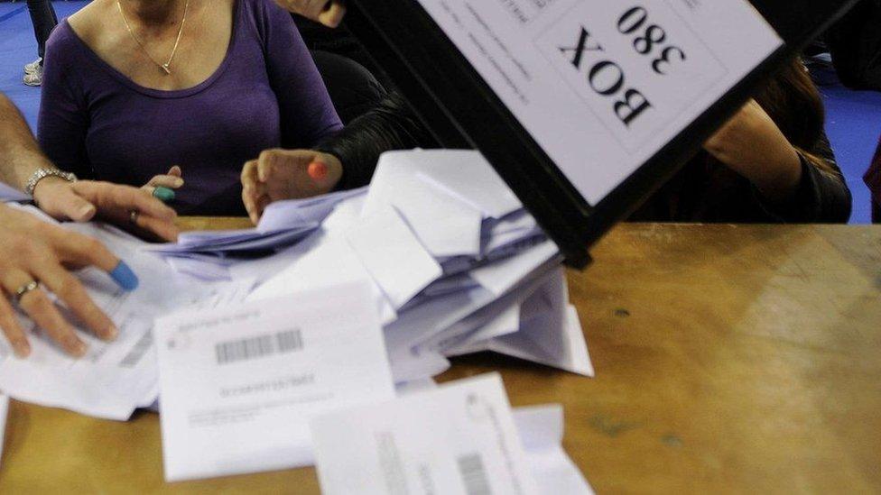 Ballot papers being tipped onto a desk