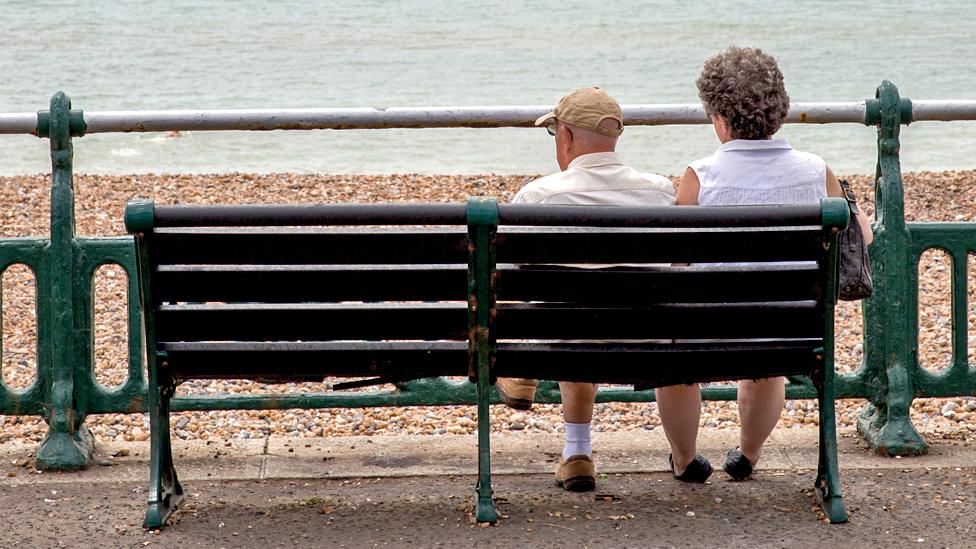 Couple sitting on a bench on the beachfront