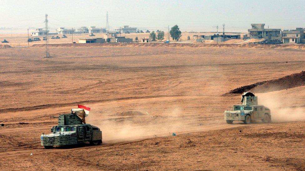 Kurdish Peshmerga fighters drive vehicles near the frontline during a battle with Islamic State militants at Topzawa village, near Bashiqa, Iraq (24 October 2016)