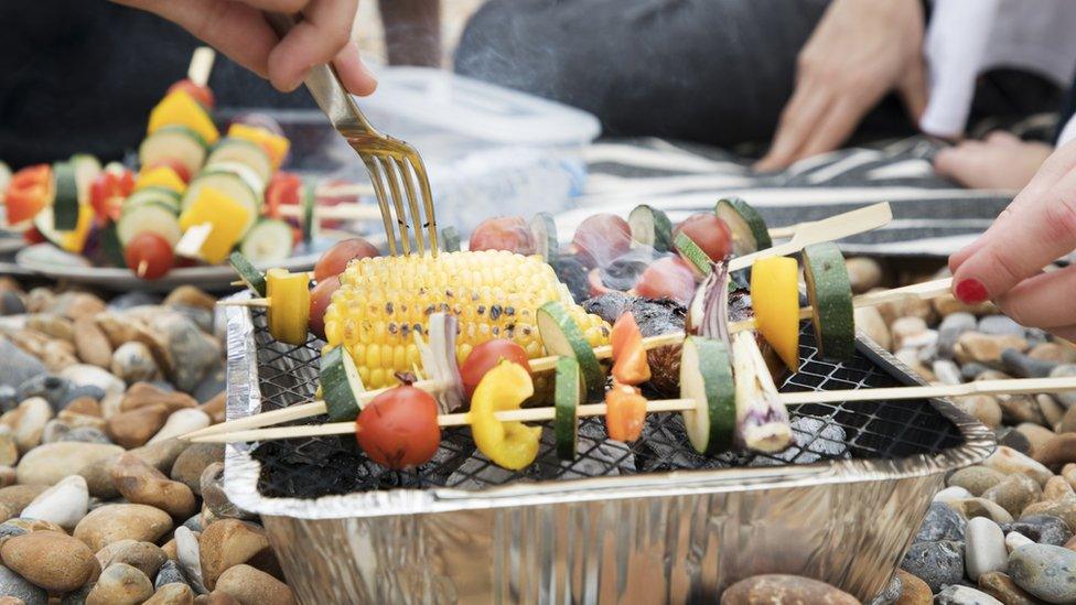 people-cooking-food-on-disposable-barbecue.