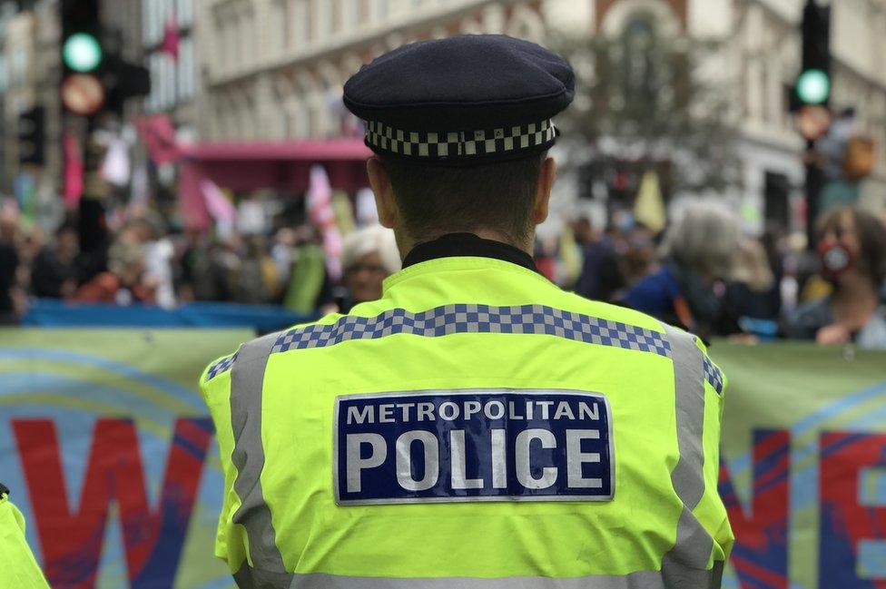 Policeman faces protesters