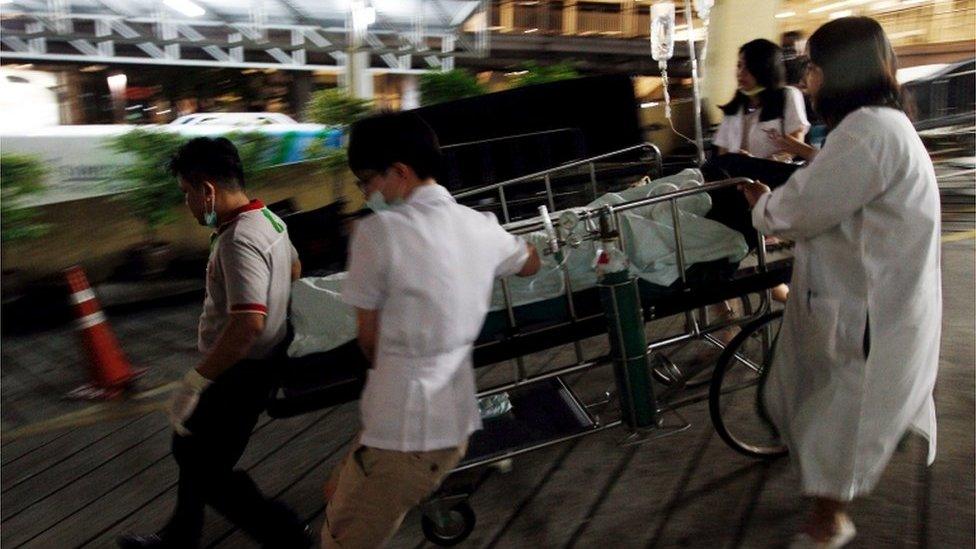 Medical workers rush the victim of a blast at the Erawan shrine to a nearby hospital in central Bangkok 17 August 2015