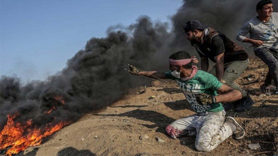 Palestinian prepares to fire a slingshot at a Gaza border protest (15/05/18)