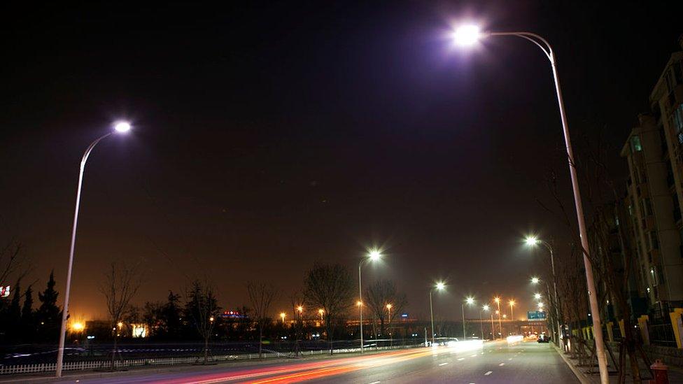 Traffic passes along a street in lit up by LED lights that are in a testing phase in Tianjin, China