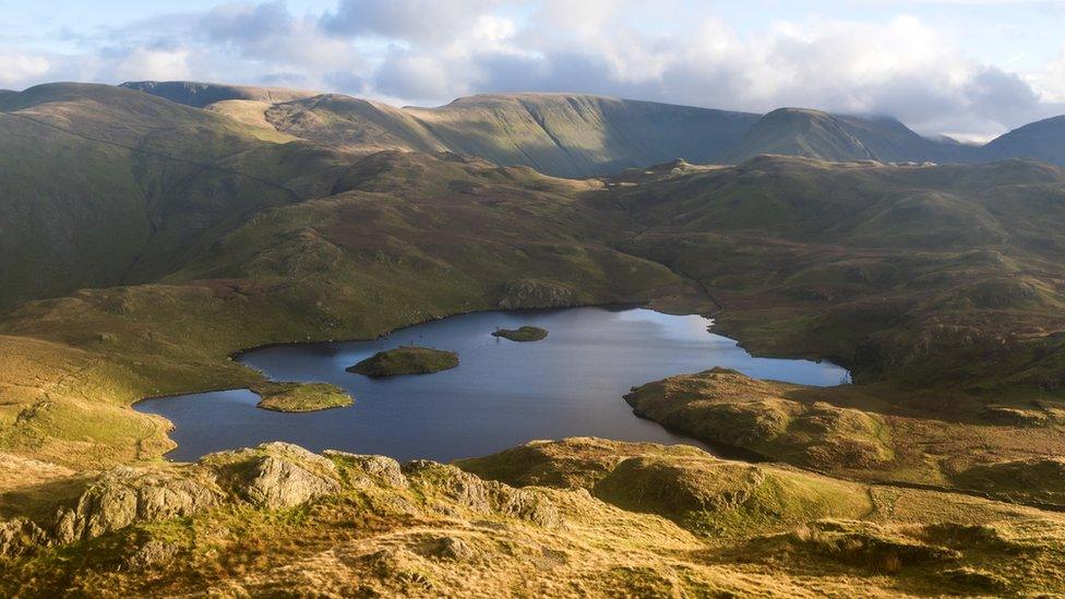 Aerial view of a tarn surrounded by hills