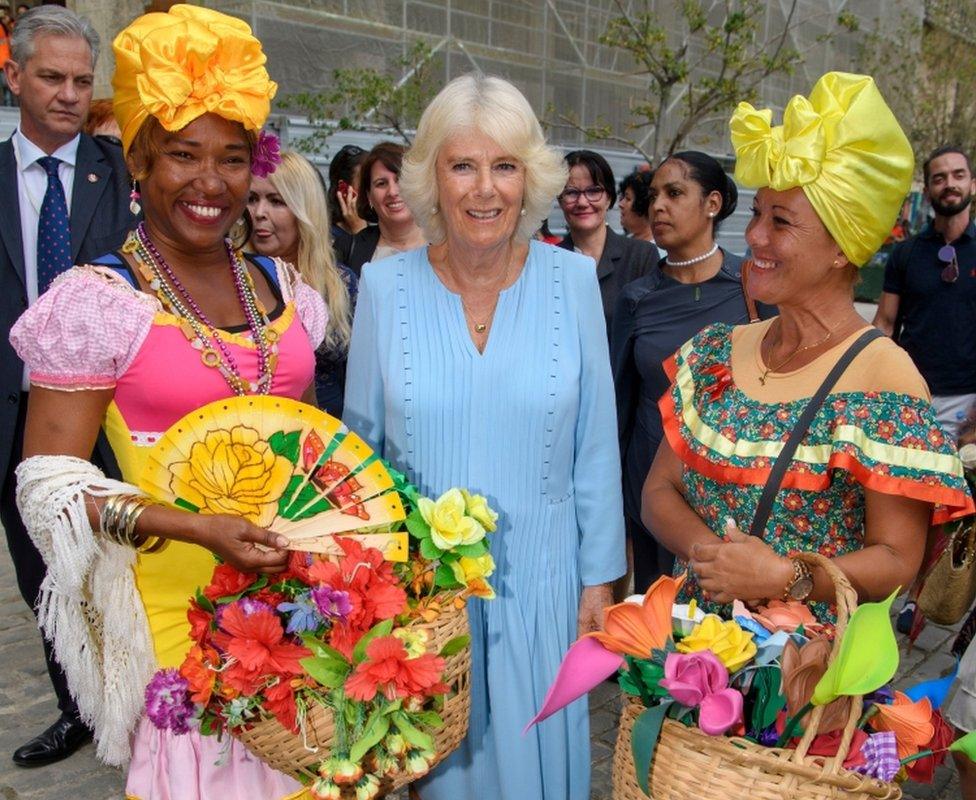 Camilla poses with two ladies in traditional Cuban clothing