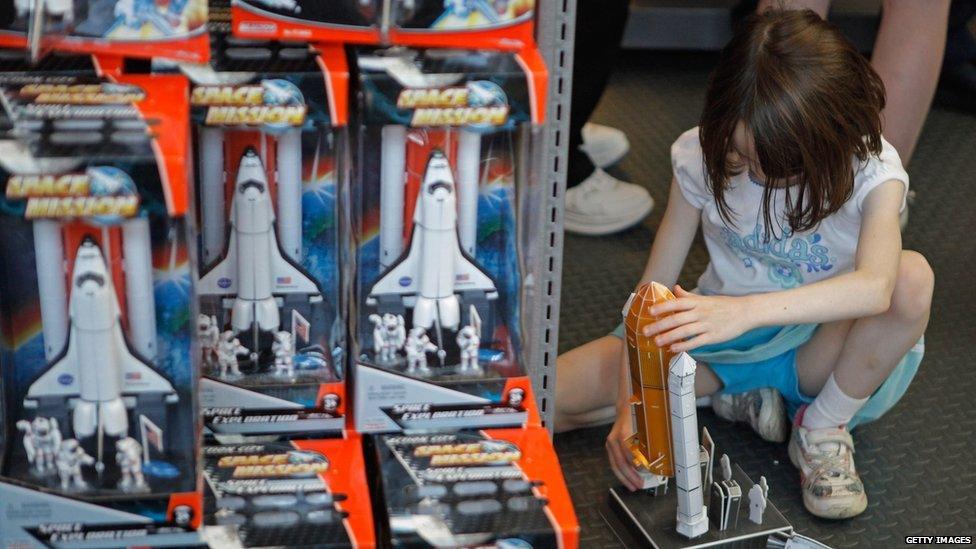 A young girl playing with a spaceship toy