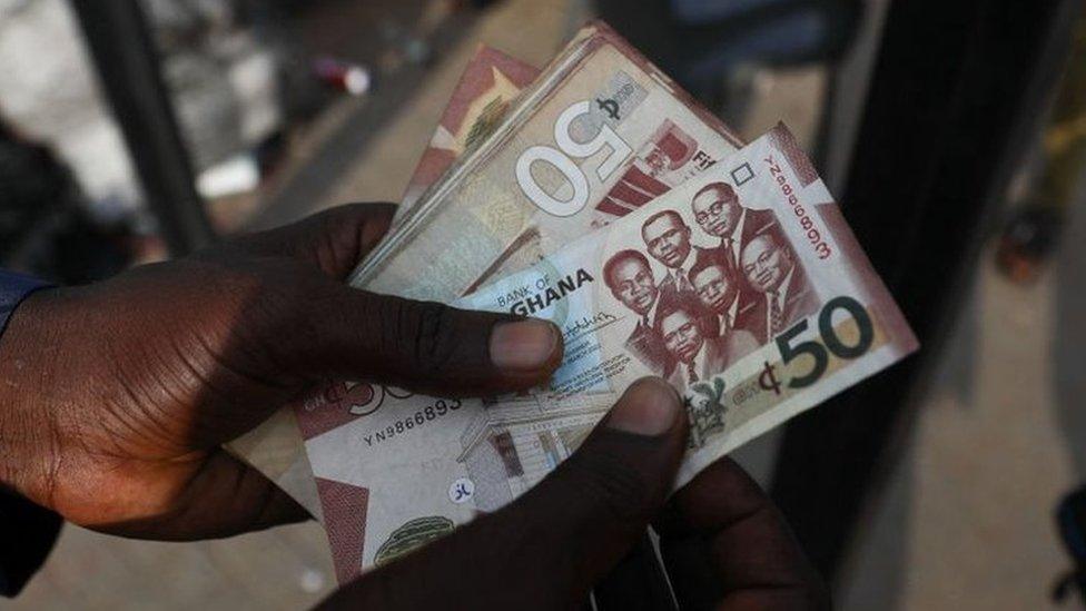 Man holds Cedi notes