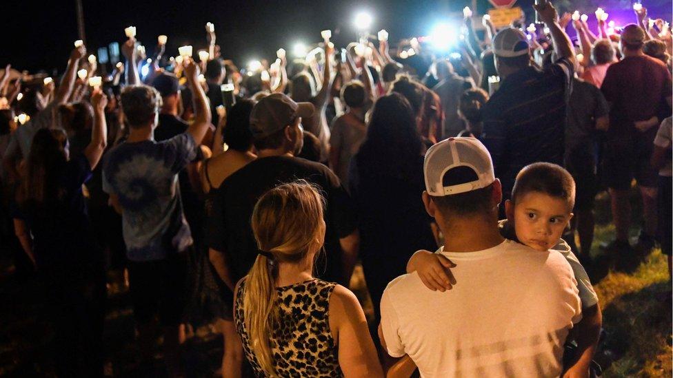 A crowd of people at a candlelit vigil