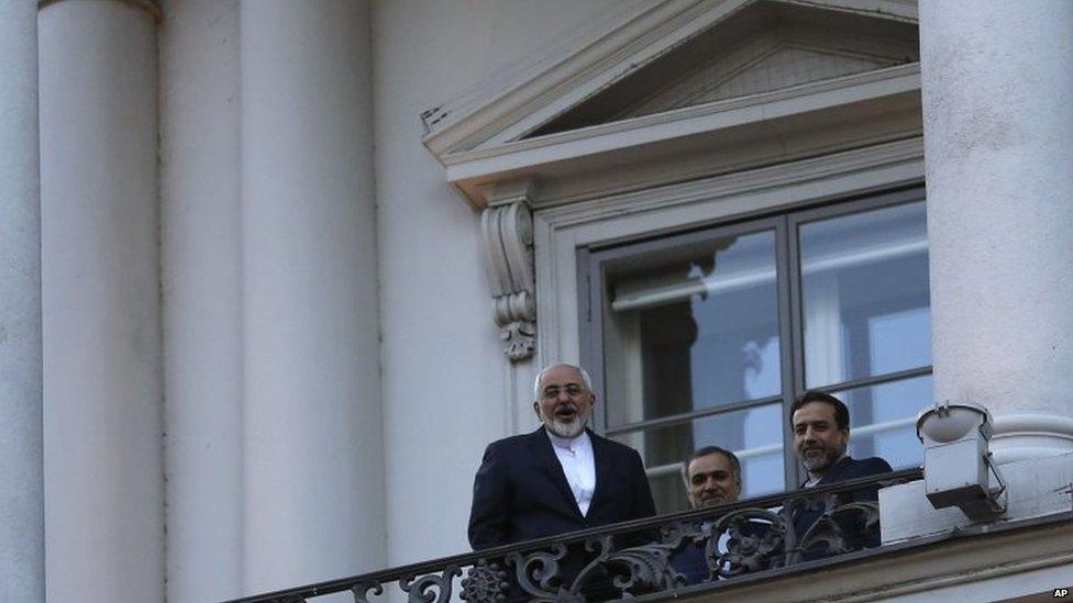 Iranian Foreign Minister Mohammad Javad Zarif (left) talks to journalist from a balcony of the Palais Coburg hotel in Vienna