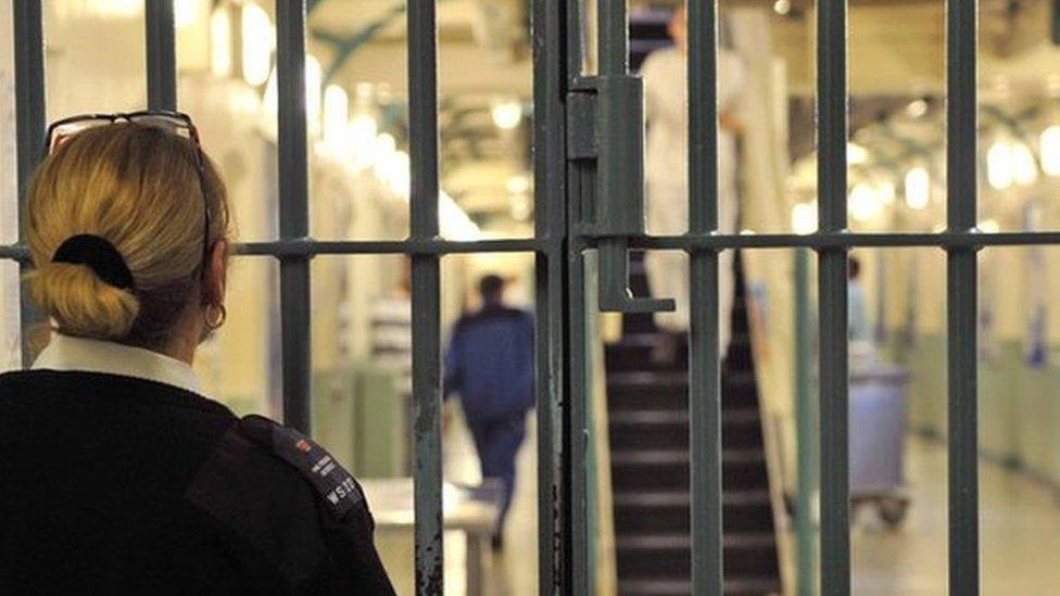 An anonymous female prison officer locks a door at Wormwood Scrubs