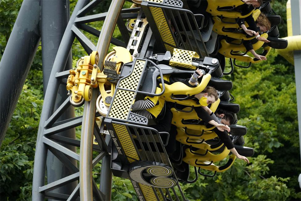 People ride a rollercoaster