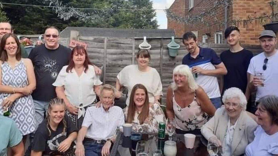 Robert and Teresa with several other people at a family barbecue