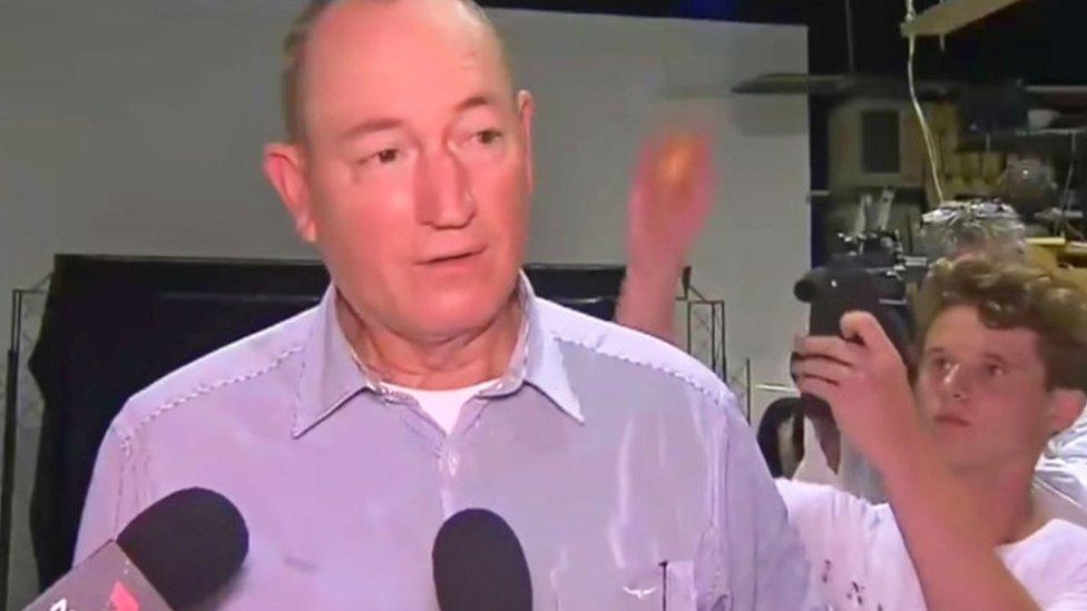 A screenshot of teenager Will Connolly preparing to crack an egg on Fraser Anning's head