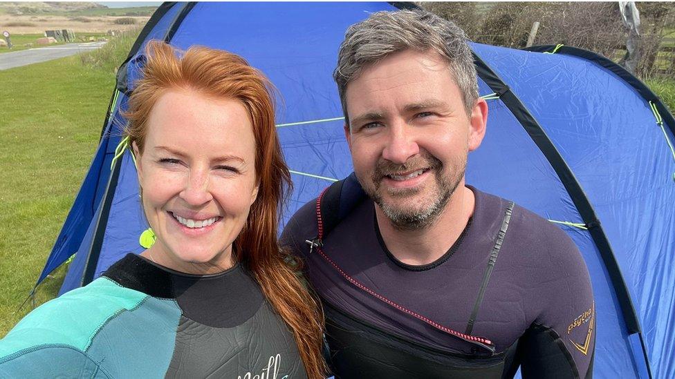 Man and woman stood outside a tent