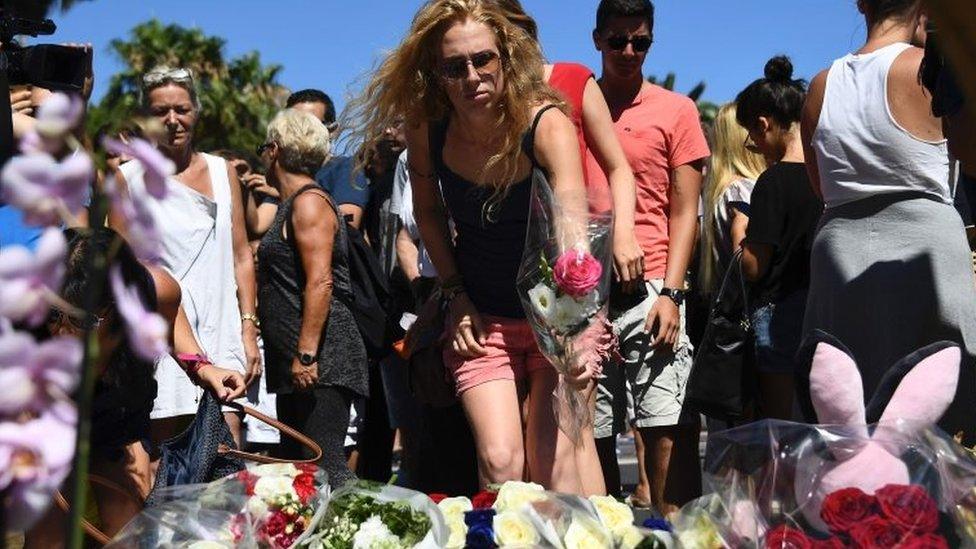 People lay flowers on the street of Nice to pay tribute to the victims of Thursday's attack