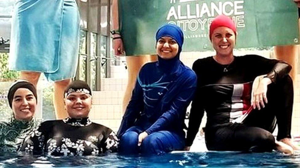 Members of the campaign group Citizen Alliance of Grenoble protest at a community pool in Grenoble, France